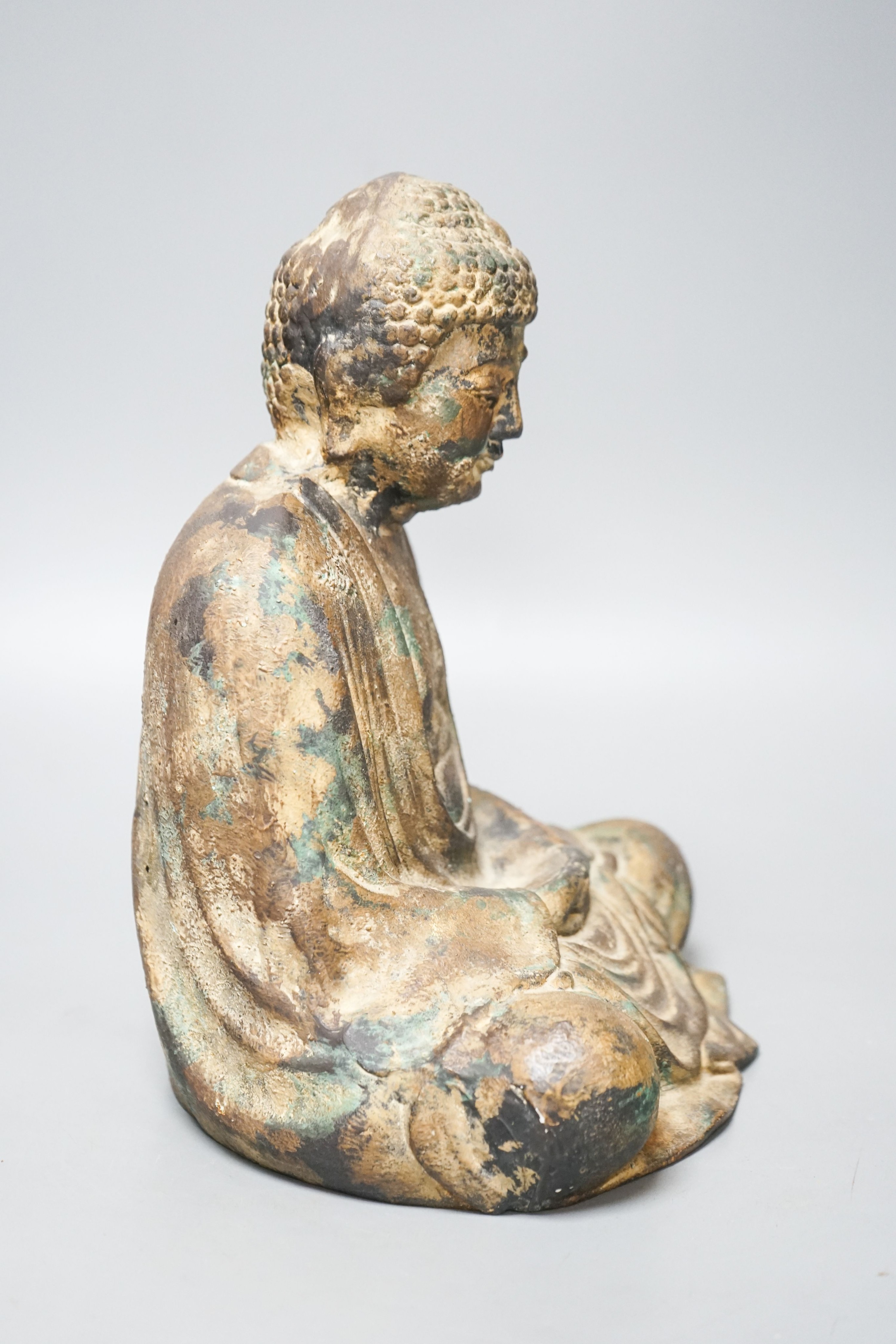A South East Asian cast iron figure of a seated Buddha 28cm